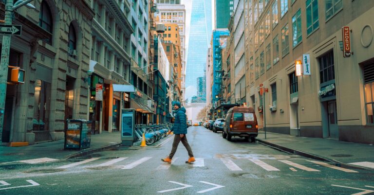 A person crosses a street in downtown Manhattan, New York during winter.